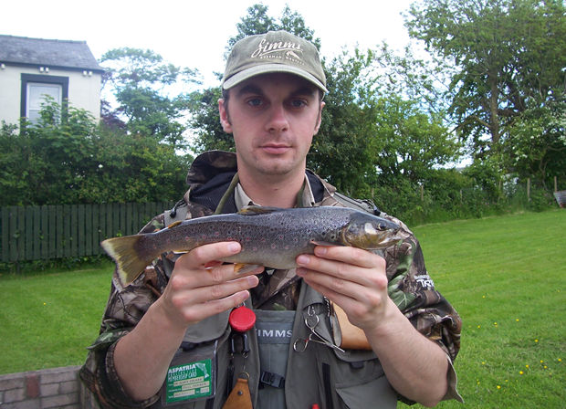 Dr. Clark Colman dispays a fine, fin perfect brownie taken from club waters.